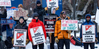 Park City Ski Patrol strikers hold signs