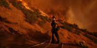 A firefighter battles the Palisades Fire in Mandeville Canyon Saturday, Jan. 11, 2025, in Los Angeles. 