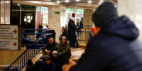 People take shelter inside a metro station during a Russian military strike, in Kyiv