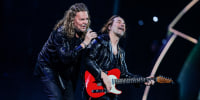 Fernando Olvera (with microphone), left, and Sergio Vallin (with guitar) perform on stage