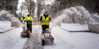 Workers clear snow.