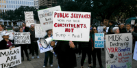 Attendees hold signs during a rally at Houston City Hall on Monday, Feb. 17.  