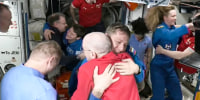 People hug inside of a spacecraft