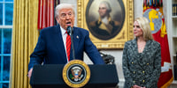 Donald Trump, left, speaks at a podium next to Pam Bondi, who watches