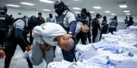Alleged members of the Venezuelan criminal organization Tren de Aragua and from the Salvadoran gang MS-13 being subdued upon their arrival at the Terrorism Confinement Center in the city of Tecoluca, El Salvador, in an image released on March 31.