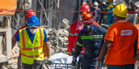 Rescue teams members carry a body from the Jet Set nightclub  