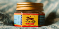 A small jar of Tiger balm, a popular traditional ointment for relief of muscle aches.
