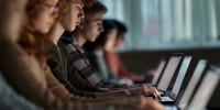 A group of students studying over laptops on a class at school.