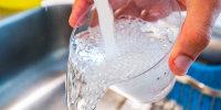 Tap water is poured into a cup from a faucet
