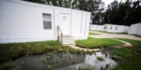 Fetid water pools outside a mobile home in Lowndes County, Ala.