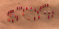 A drone view of detainees forming the letters SOS with their bodies in the courtyard