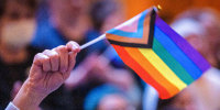 A person waves a pride flag