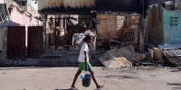 A man carries his belongings as he flees gang violence in Haiti