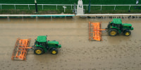 Tractors prepare the muddy track at Churchill Downs 