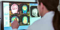 Female doctor looking at MRI scanner monitor