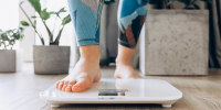 Close-up of bare feet stepping onto a digital scale, symbolizing health, fitness, and mindfulness in a modern home setting
