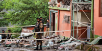 Army soldiers stand guard at a mosque building damaged by a suspected Indian missile attack near Muzaffarabad