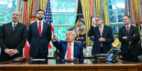 Trump, center, speaks to reporters.