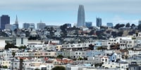 An aerial view of homes in front of the San Francisco skyline