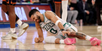 Jayson Tatum winces in pain on the ground after being injured against the New York Knicks