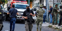 Members of the general prosecutor's office and the Navy stand guard near a vehicle involved in a shootout in Veracruz, Mexico, Monday, May 12, 2025.