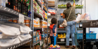 A child carries a basket of food at a food bank.