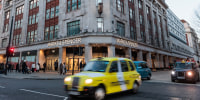 Vehicles pass in front of Marks & Spencer in London