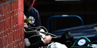 A member of the Portland Fire and Rescue Community Health Assess & Treat team pushes a patient into an ambulance