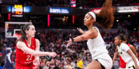 Caitlin Clark passes around Angel Reese