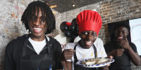 Members of OSB laughing while holding nems during a cooking class.