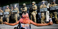 A protester in front of a line of California National Guard