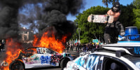 A Waymo taxi is vandalized while another burns 