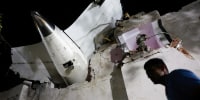 A person walks past debris at the crash site after an Air India aircraft crashed during take-off from an airport in Ahmedabad, India, on June 12, 2025. 