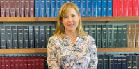Minnesota House Speaker Melissa Hortman stands in front of Minnesota law books in her office in St. Paul in 2023. 