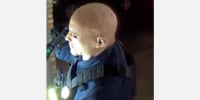 A man knocking on a door in security camera footage.