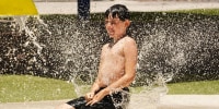 A boy plays at a splash pad at Anthem Community Park