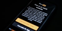 The age-restriction warning screen of the website PornHub is displayed on a digital phone screen