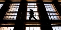A guard on the catwalk above the cells of a prison