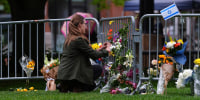 A woman places flowers at a makeshift memorial for victims of an attack outside of the Boulder County Courthouse Tuesday, June 3, 2025, in Boulder, Colo.