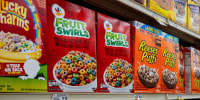 Two boxes of the cereal "Fruit Swirl" next to two boxes of the cereal "Reese's Puffs"