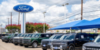 Ford vehicles are seen for sale on a dealership lot outside