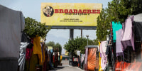 The sign for Broadacres Marketplace is seen outside in a parking lot surrounded by tents