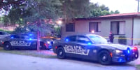 Police cars with lights on in front of a house outside