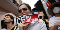 A protester holds a sign that reads "Ice Go Home"