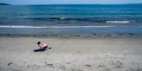 A person sits on the beach.