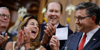House Speaker  Mike Johnson holds up the final vote tally