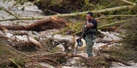A Sheriff's deputy pauses while combing through the banks of the Guadalupe River near Camp Mystic, Saturday, July 5, 2025, in Hunt, Texas.