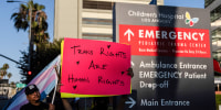 A person holds a sign that says "Trans Rights Are Human Rights"