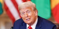 Donald Trump speaks while seated at a table