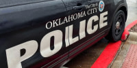 An Oklahoma City Police vehicle parked outside.